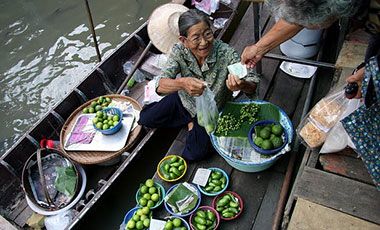 A woman trades her produce in a floating market in Bangkok, Thailand.