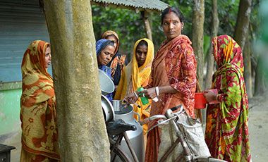A woman milk collector collecting morning milk form women dairy farmers in Bangladesh