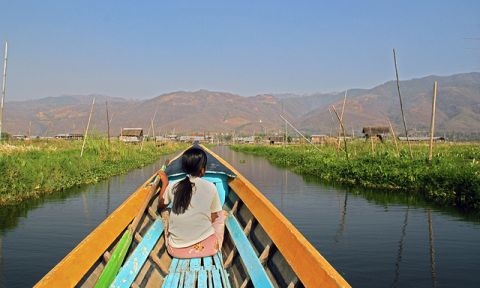 A young woman sitting on a water taxi in on Inle Lake, Myanmar.