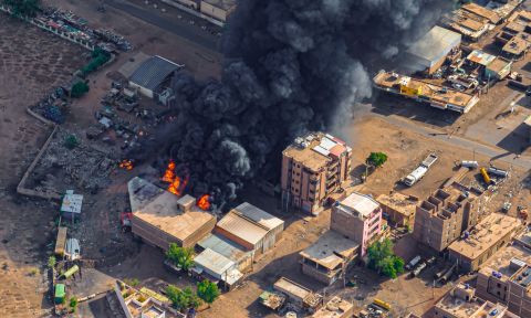 Aerial image of burning buildings with thick black smoke in urban landscape