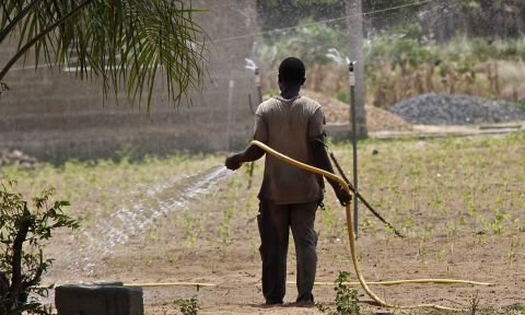 A farmer in Ghana uses a sprinkler irrigation system