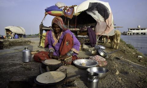 woman cooks next to a shack