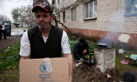 Man carries a food assistance box in Eastern Ukraine