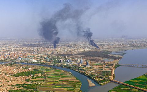 Two large plumes of smoke over city in aerial view