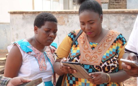 Two women look at tablet screen held by one