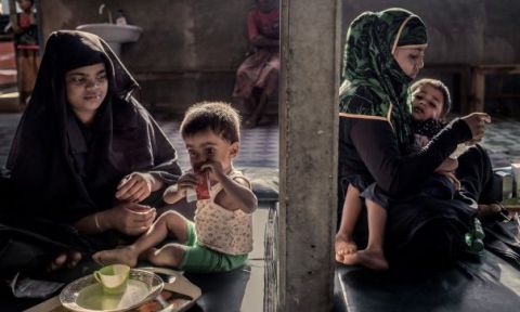 Refugee women sitting with children