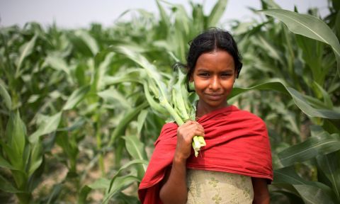 Girl holding harvested crops.