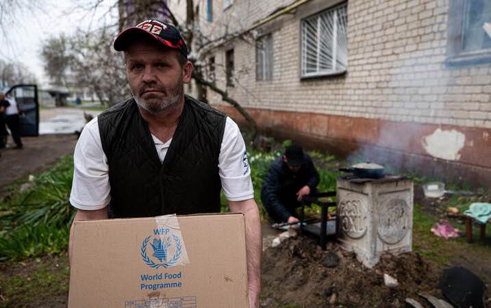 Man carries a food assistance box in Eastern Ukraine