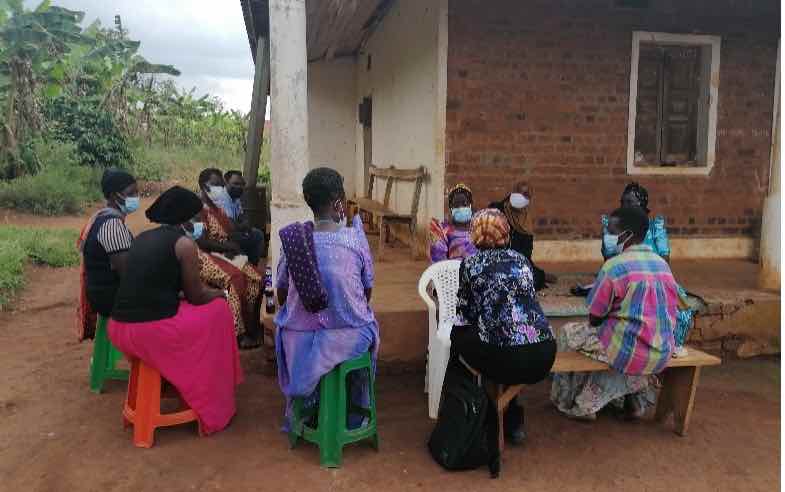 Group of women seated and talking next to building