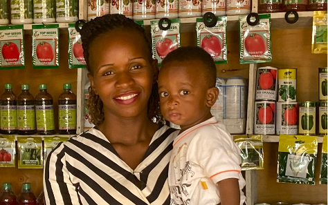 Woman holding toddler in front of shop shelves
