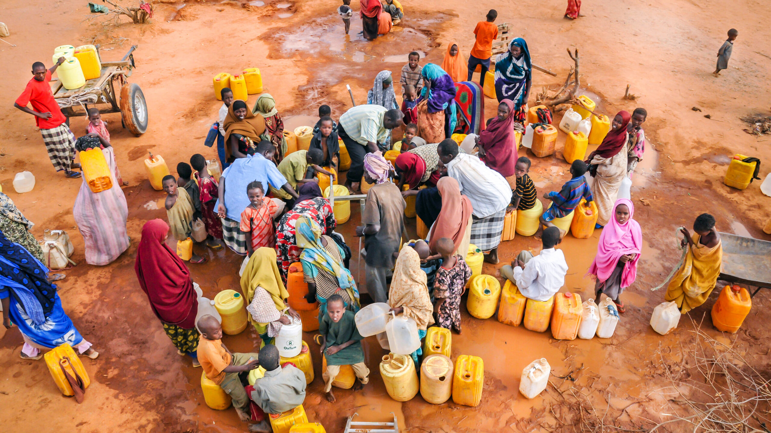 Overhead image of people with water jugs clustered together.