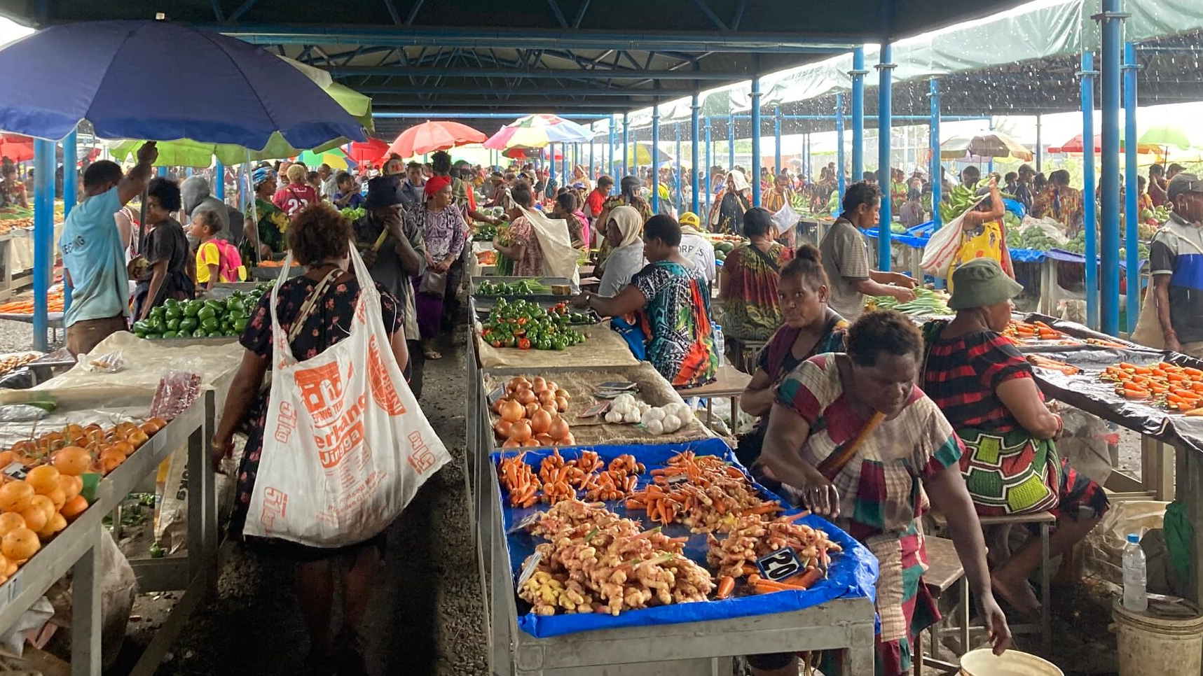 Men and women in covered produce market
