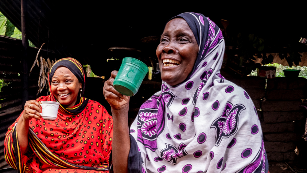Two women holding mugs and smiling