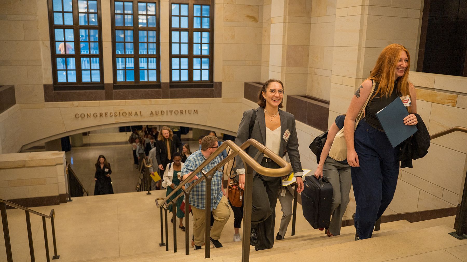 Women and men walk up stairs from Congressional Auditorium